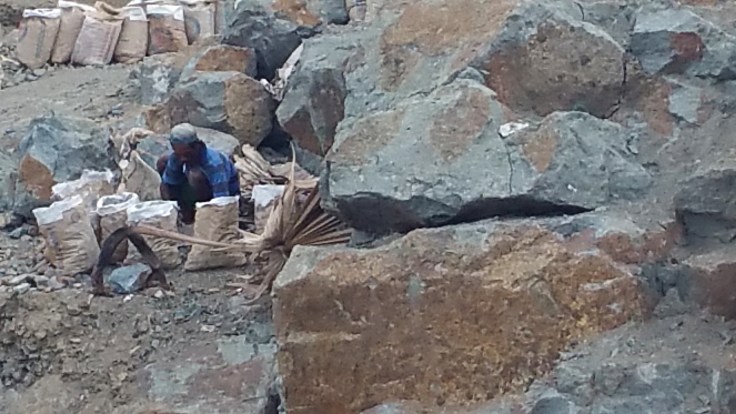 Some of the poor in Labuan Bajo, breaking rocks to sell bags of stones for building